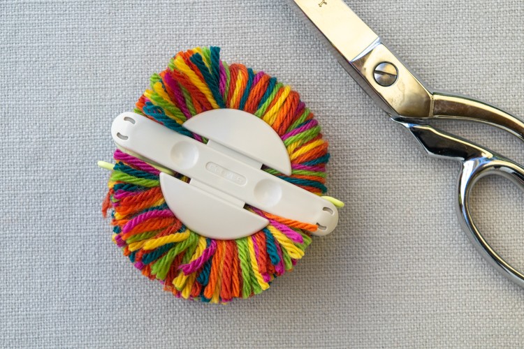 Cut the yarn for the rainbow beanie pompom