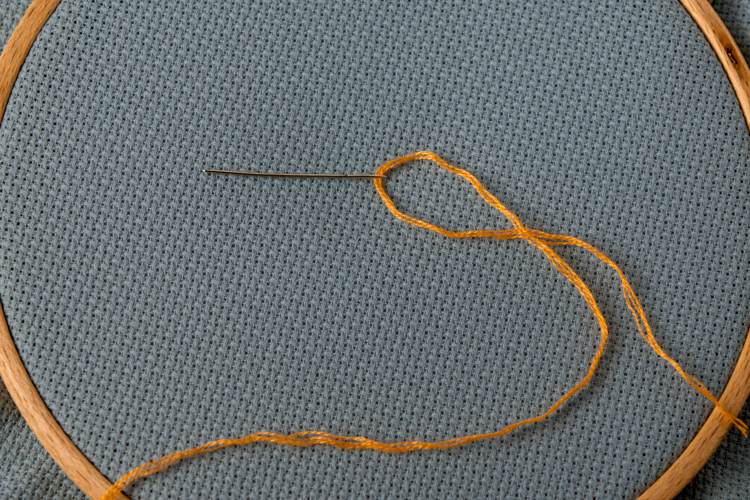 Beginner Cross Stitch thread the needle with separated strands of floss